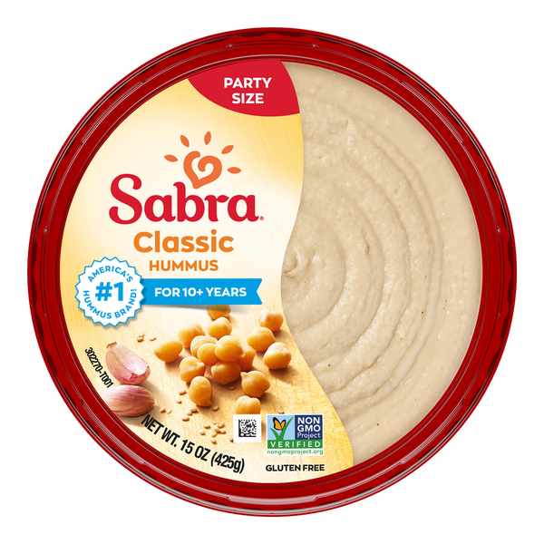 A round container of Sabra Classic Hummus with a red lid and label showing chickpeas and garlic.